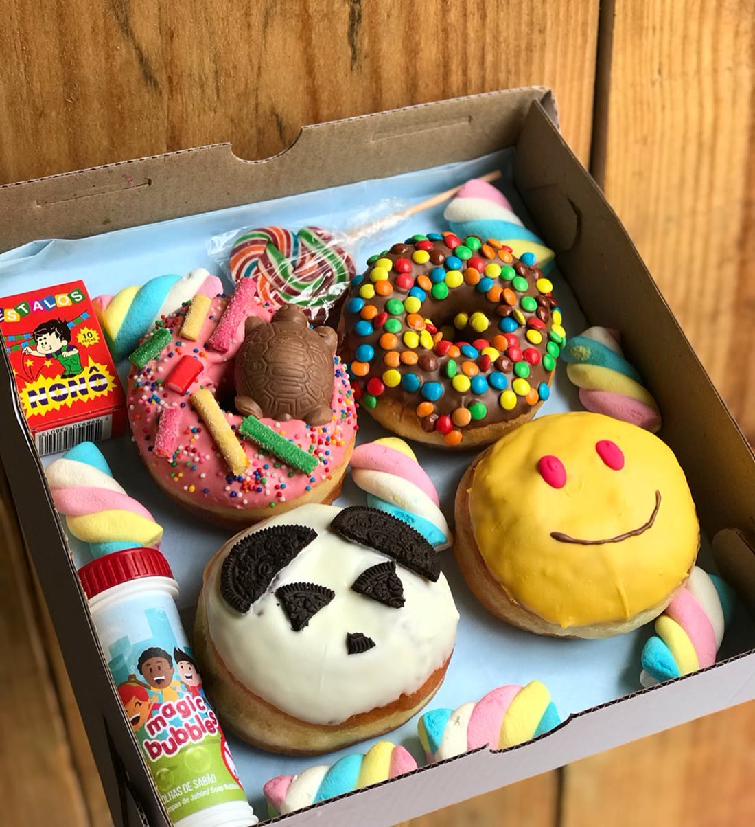 Caixa de festa com minis donuts decorados de panda, carinha e granulado